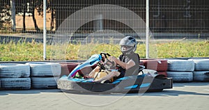 A young man drives a go kart at circuit