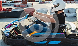 A young man drives a go kart at circuit