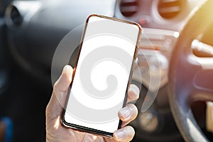 A young man drives with a phone in his hand