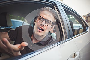 Young man driving a car shocked about to have traffic accident, windshield view.