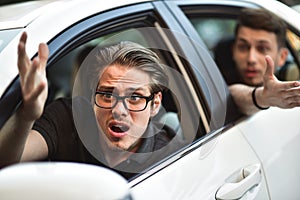 Young man driving a car shocked about to have traffic accident, windshield view.