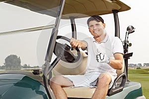 Young man driving cart on a golf course