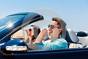 Young man driving with girlfriend in convertible