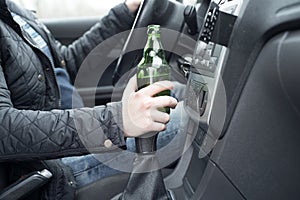 Young man driving his car while drinking alcohol