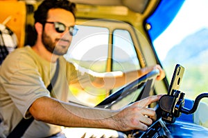 Young man driving house on wheels truck by mountains road in summer day