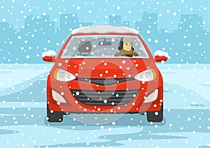 Young man driving a red mini car on a snowy city road. Front view.
