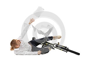 Young man dropping documents while falling off bicycle