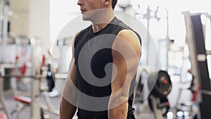 Young man with dumbbell in gym