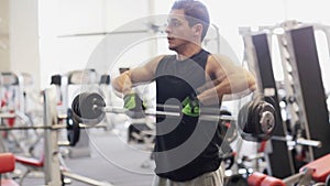 Young man with dumbbell in gym