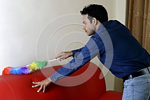 Young man dusting home