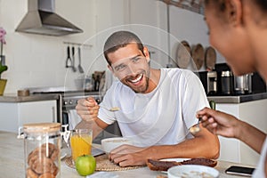 Young man eating cereal at breakfast