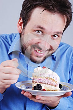 Young man eating colorful cake, isolated