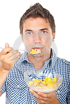 Young man eating cornflakes cereals