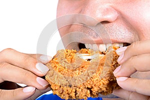 Young man eating fried chicken