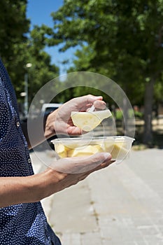 Young man eating a fruit salad outdoors