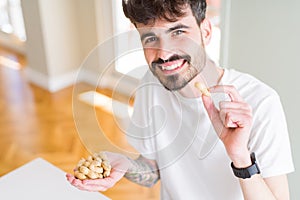 Young man eating peanuts, close up of hand with a bunch of healthy nuts