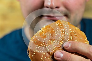 Young man eats delicious appetizing burger