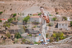 Young man on the edge of canyon in Cappodocia