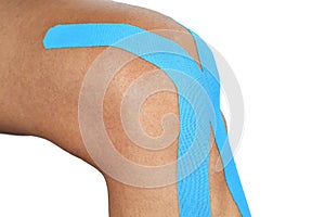 Young man with an elastic therapeutic tape in his knee