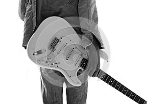 A young man with an electric guitar Leaning against a cement wa