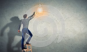 Young man with an electric light bulb