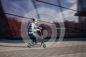 Young man on electric scooter on street