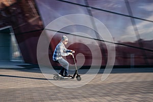 Young man on electric scooter on street