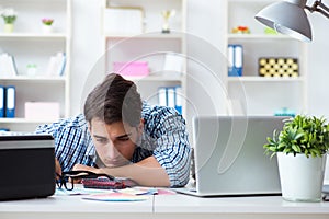 The young man employee working at copying machine in the office