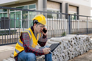 Young man engineer or construction supervisor inspecting work on project, architect wearing helmet