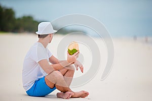 Young man enjoy beach vacation and drinking coconut