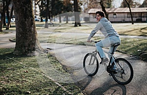 Young man enjoying a bike ride in a sunny park, expression of joy