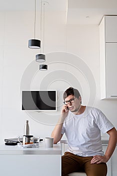 Young man Enjoying Breakfast At Home, talking on the phone