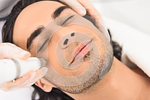 Young man enjoying cavitation facial peeling