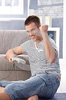 Young man enjoying computer game at home