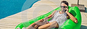 Young man enjoying leisure, lying on the air sofa Lamzac, near the pool BANNER, LONG FORMAT