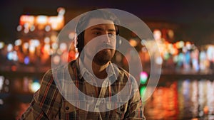 Young Man Enjoying Music with Headphones at Night in the City