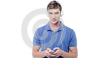 Young man enjoying music and using his mobile