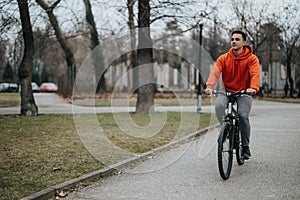 Young man enjoying a peaceful bicycle ride in the park on a cloudy day