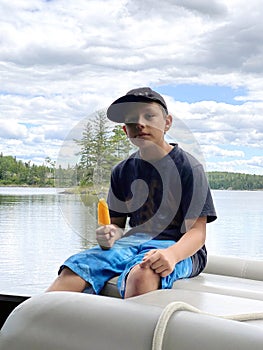 Young man enjoying a popsicle on the lake
