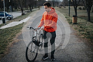 Young man enjoying a relaxing weekend bike ride in an urban park, embracing a healthy lifestyle