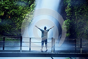 Young man enjoying Situ Gunung waterfall view