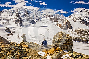 Young man enjoying the stunning view of Bernina mountain range and Morteratsch glacier