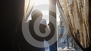 Young man enjoying view of mountain and forest in morning during sunrise with lens flare effects. Rear back view. slow