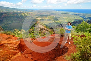 Young man enjoying a view into Waimea Canyon