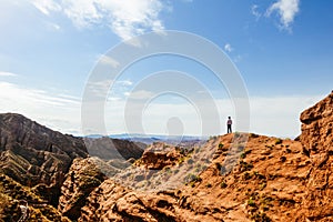 Young man enjoys the view of valley on top of hill