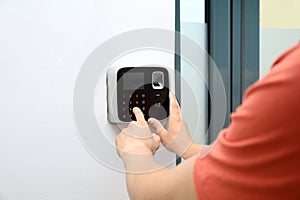 Young man entering code on alarm system keypad