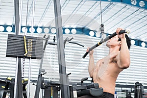 Young man execute exercise with weightlifting machine in fitness