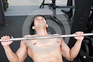young man execute exercise with weightlifting machine in fitness center. male athlete pump up muscle in gym. sporty guy working ou