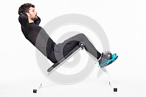 Young man exercise on bench working on abdominal muscles isolated on white background