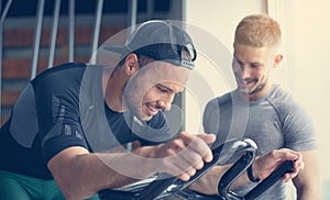 Young man exercise on stationary bikes in fitness class.